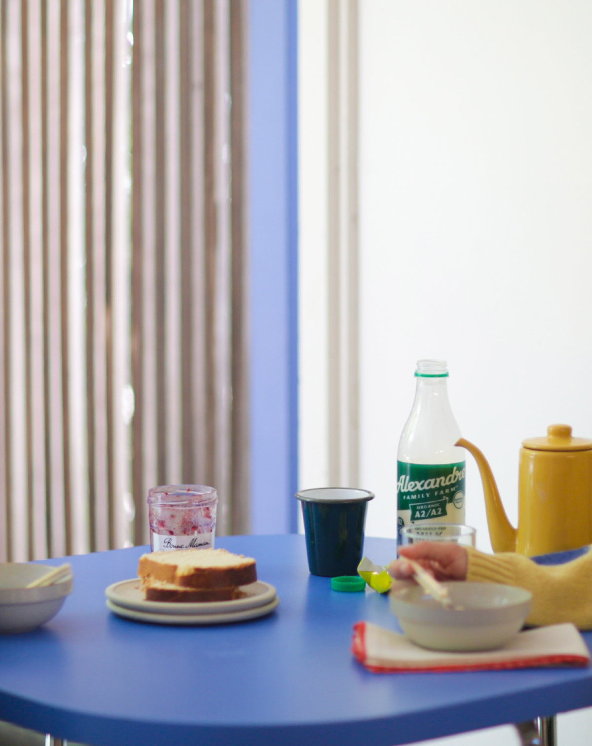 dining room table with a person's hand eating out of a bowl