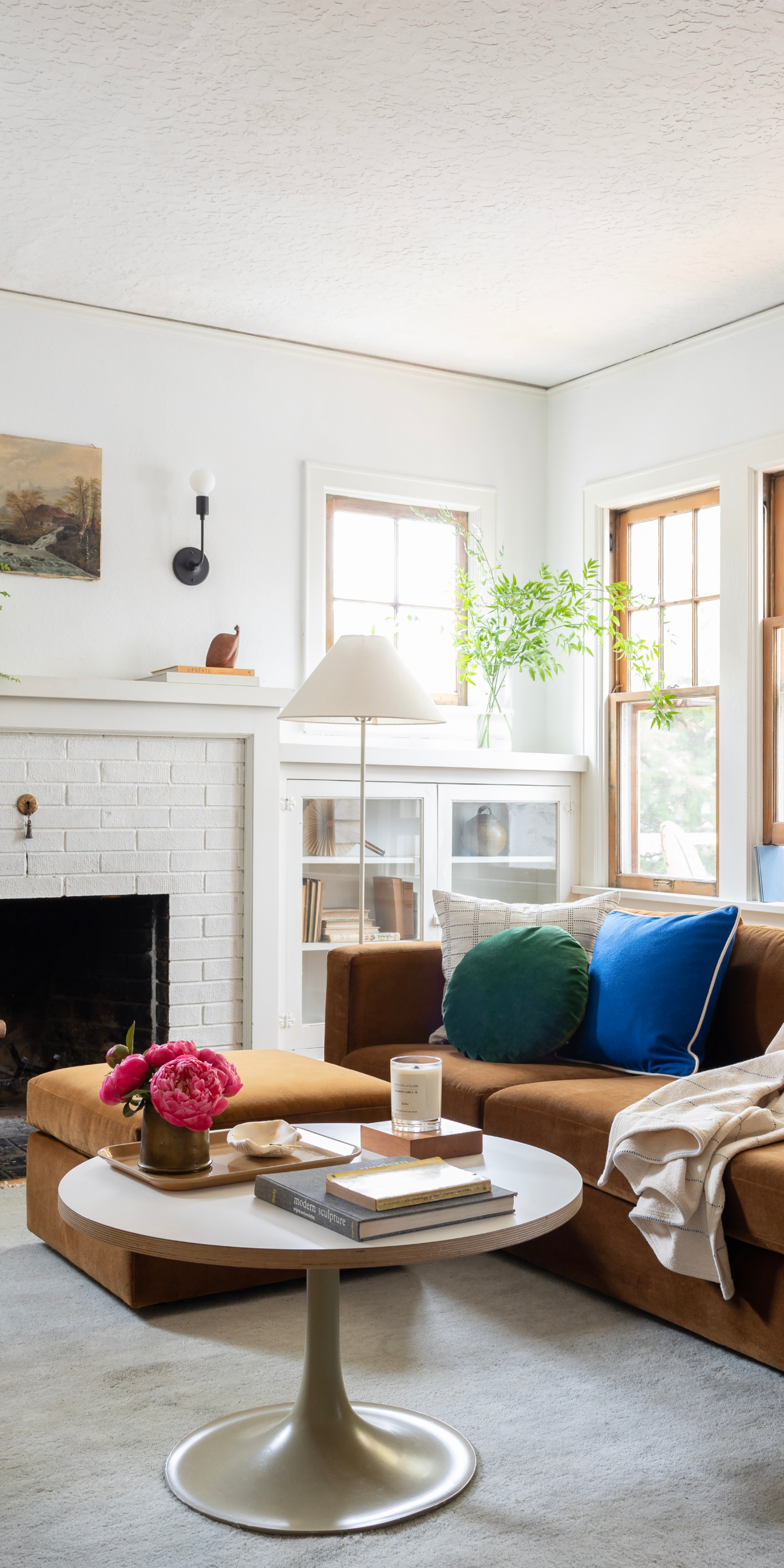 Butterscotch couch with green and blue throw pillows in bright living room