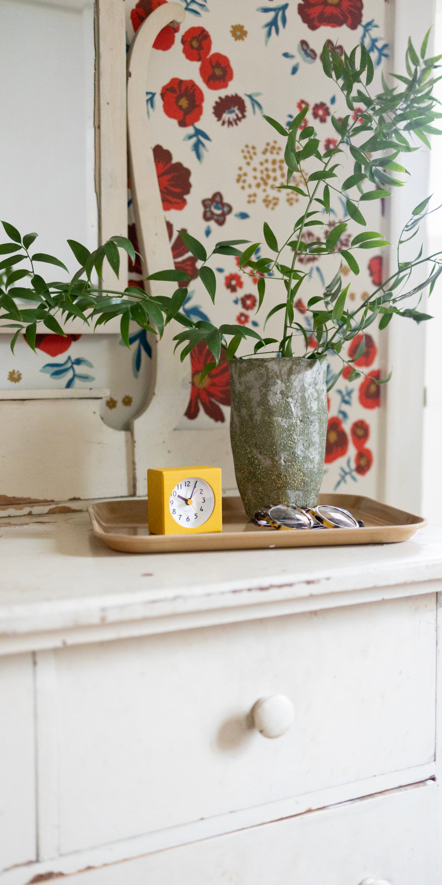 Yellow alarm clock on white distressed dresser