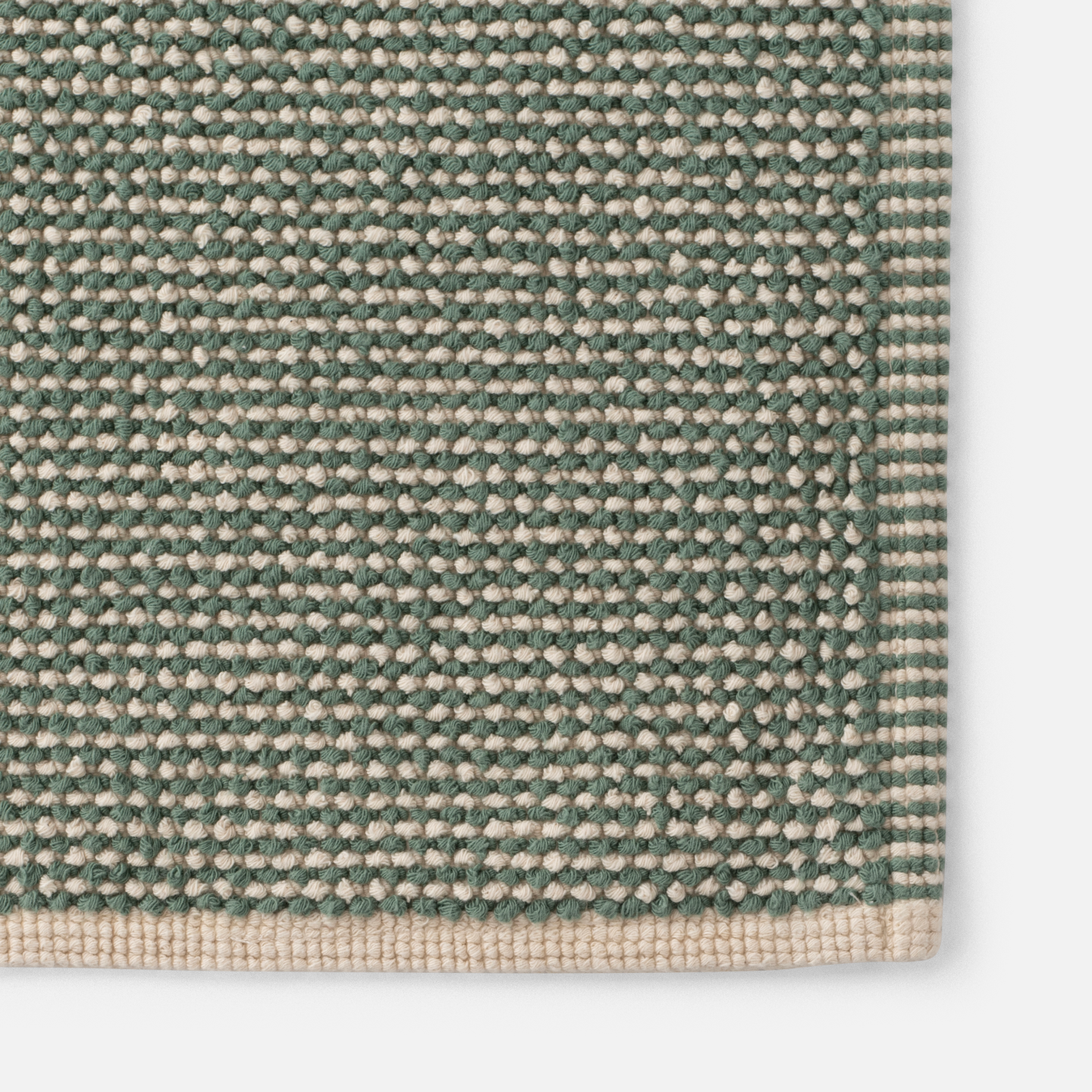 Close up of weaved green bath mat